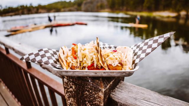 Tacos in front of a lake with watersports in the background